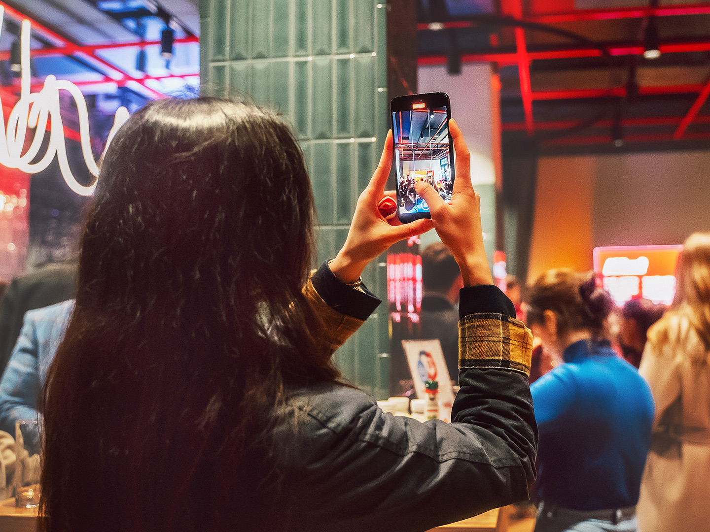 Young woman taking a phone photo in the barer41